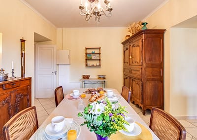 Salle à manger avec petit déjeuner servi et armoire en bois